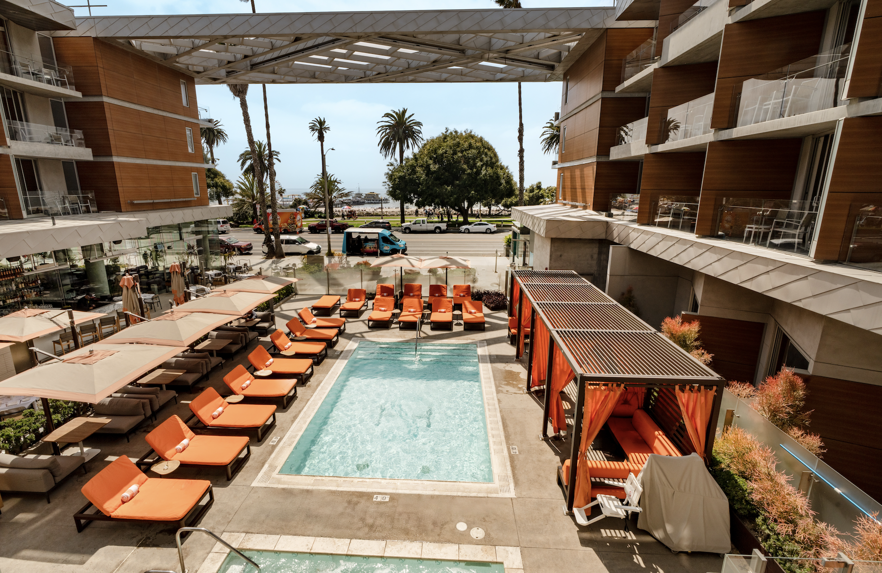 Shore Hotel pool deck with turquoise pool, orange loungers, and palms