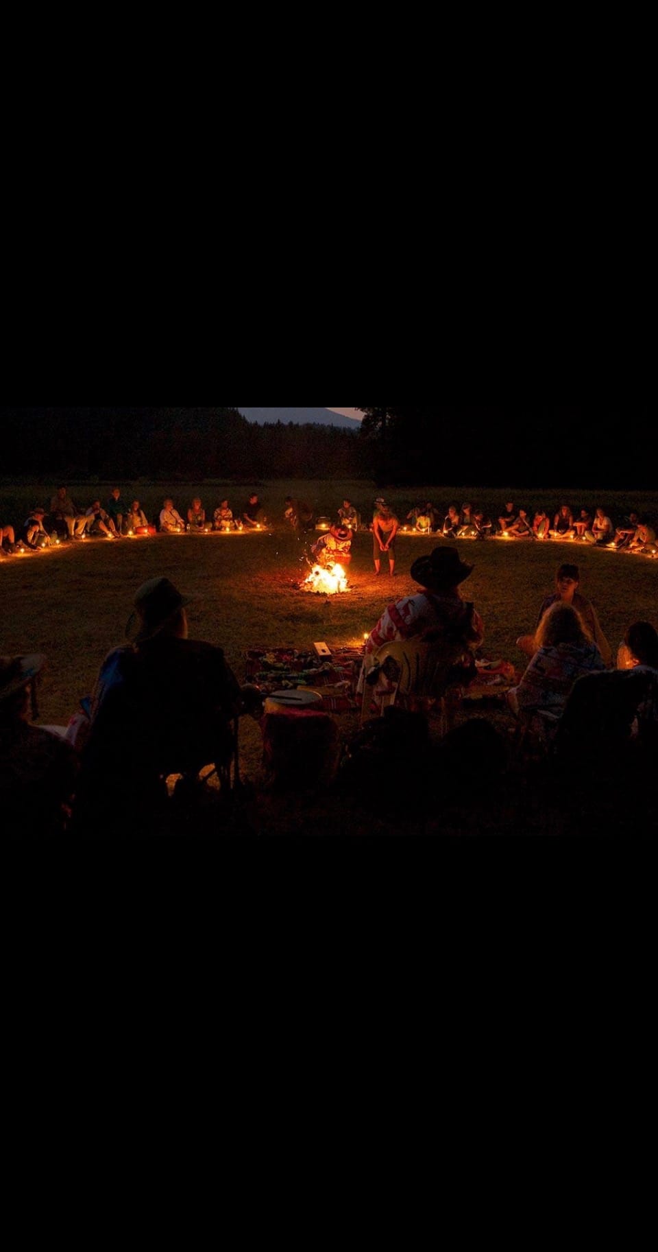 A fire circle gathered at night