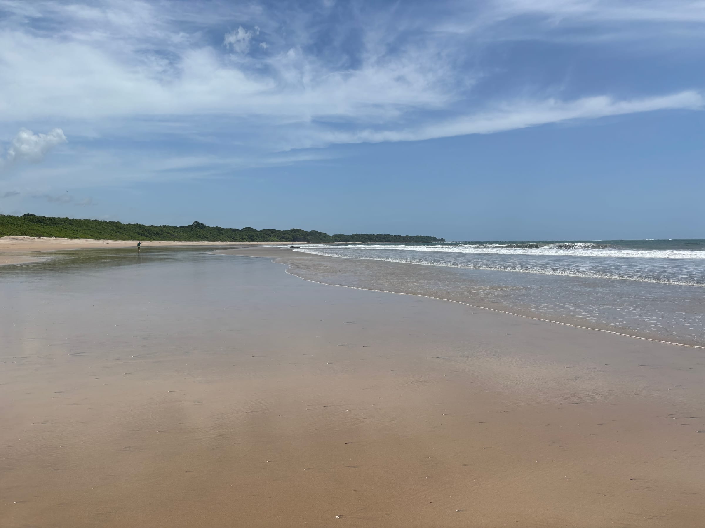 A wide, calm beach at dusk