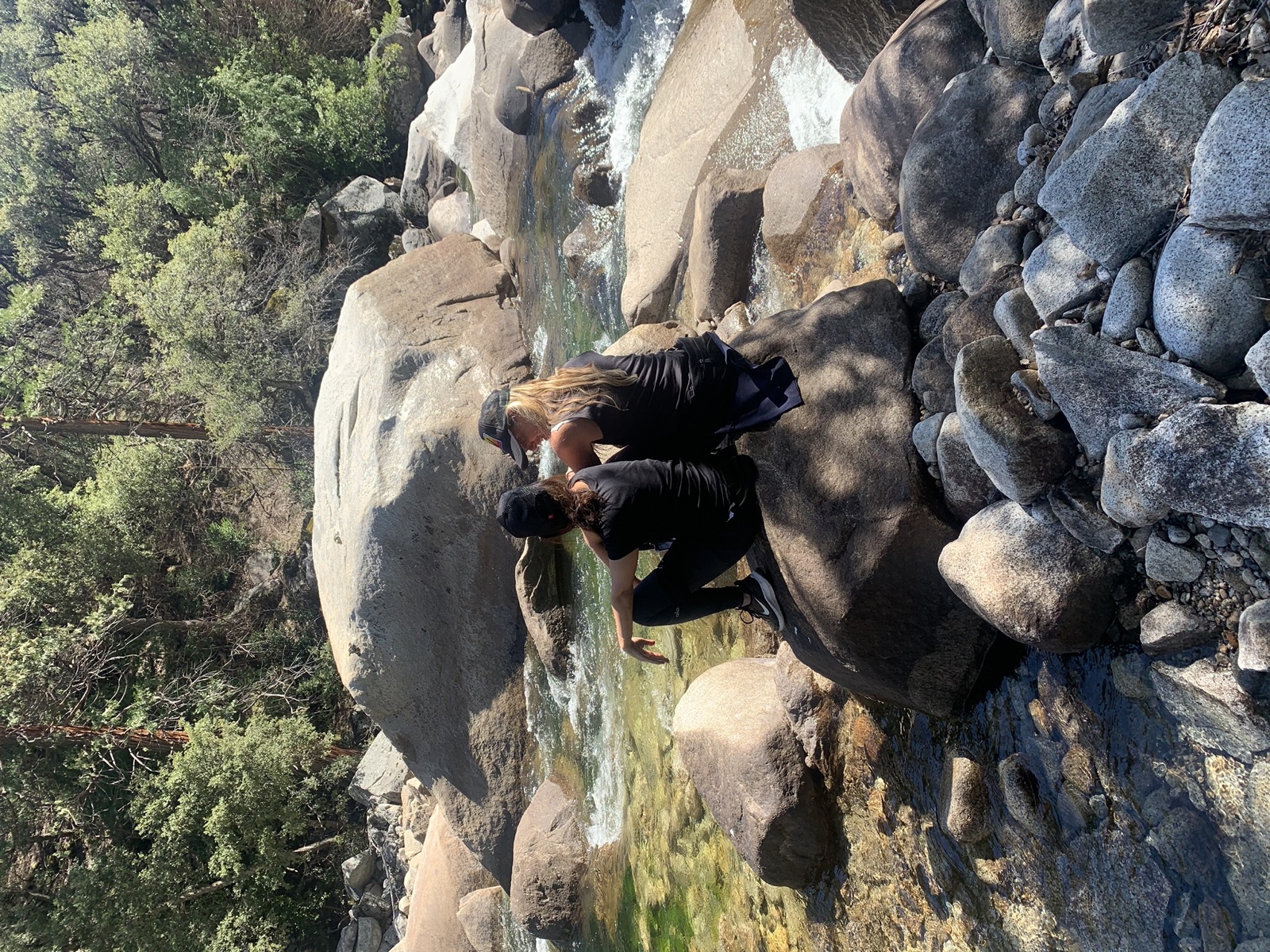 Two people resting beside a mountain creek