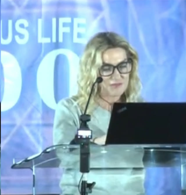 Loretta speaking at the podium at a psychedelic therapy conference